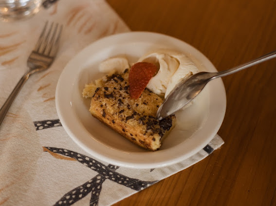 A plated dessert with cream and a strawberry on a wooden table at Wyndford