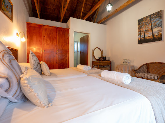 Wyndford guest room with white bedding, rolled towels and a wooden ceiling