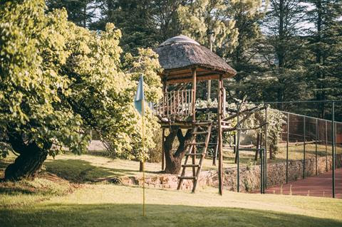 A wooden treehouse and play area beside the Wyndford tennis court